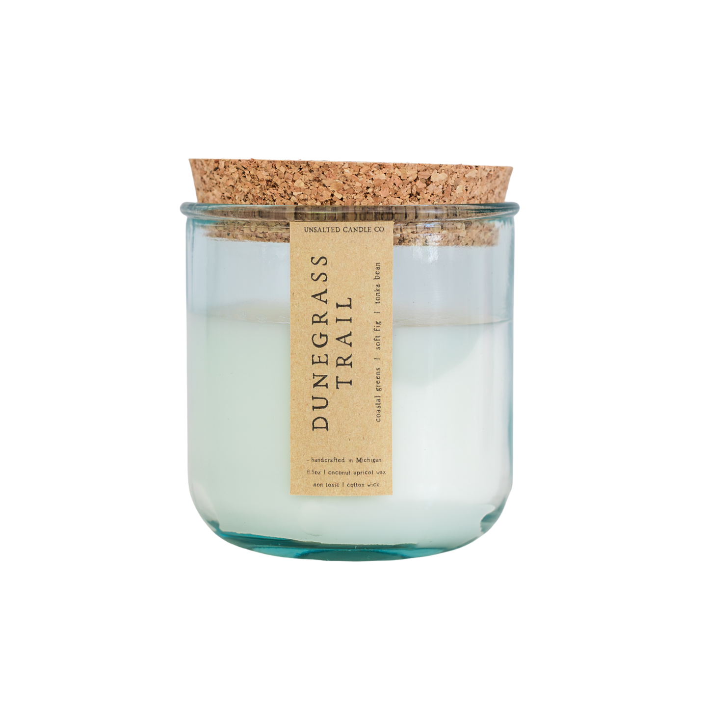 A glass jar candle with a cork lid and a beige vertical label reading 'DUNGRASS TRAIL' on a plain white background.